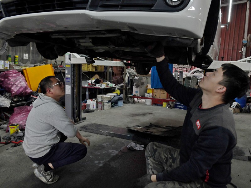 成宥汽車黃老闆與員工查看車輛狀況