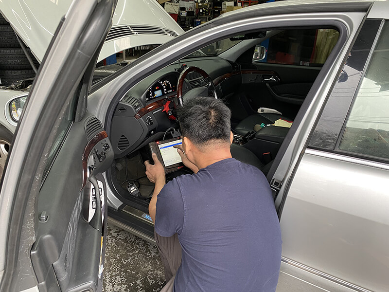 戴老闆正在用診斷電腦查看車輛問題中。